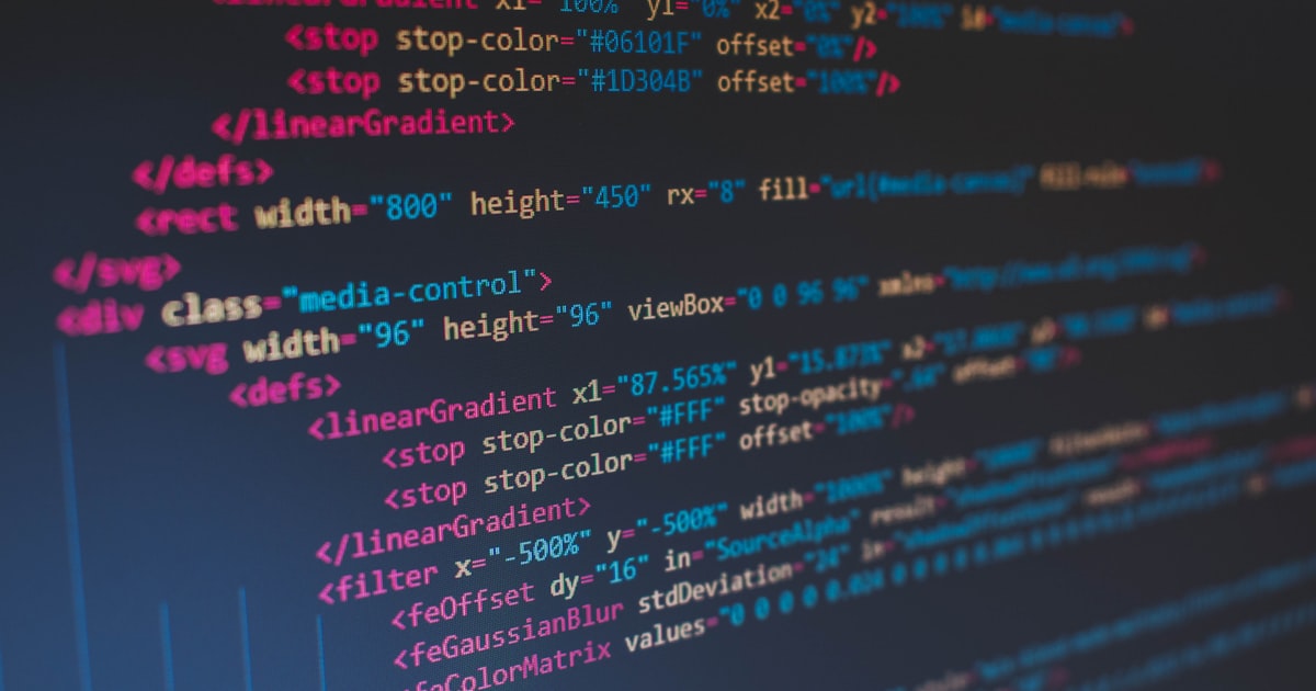 A close-up of code on a dark screen with vivid syntax highlighting in blue, orange, and white — the technical surface of how AI platforms read your site.